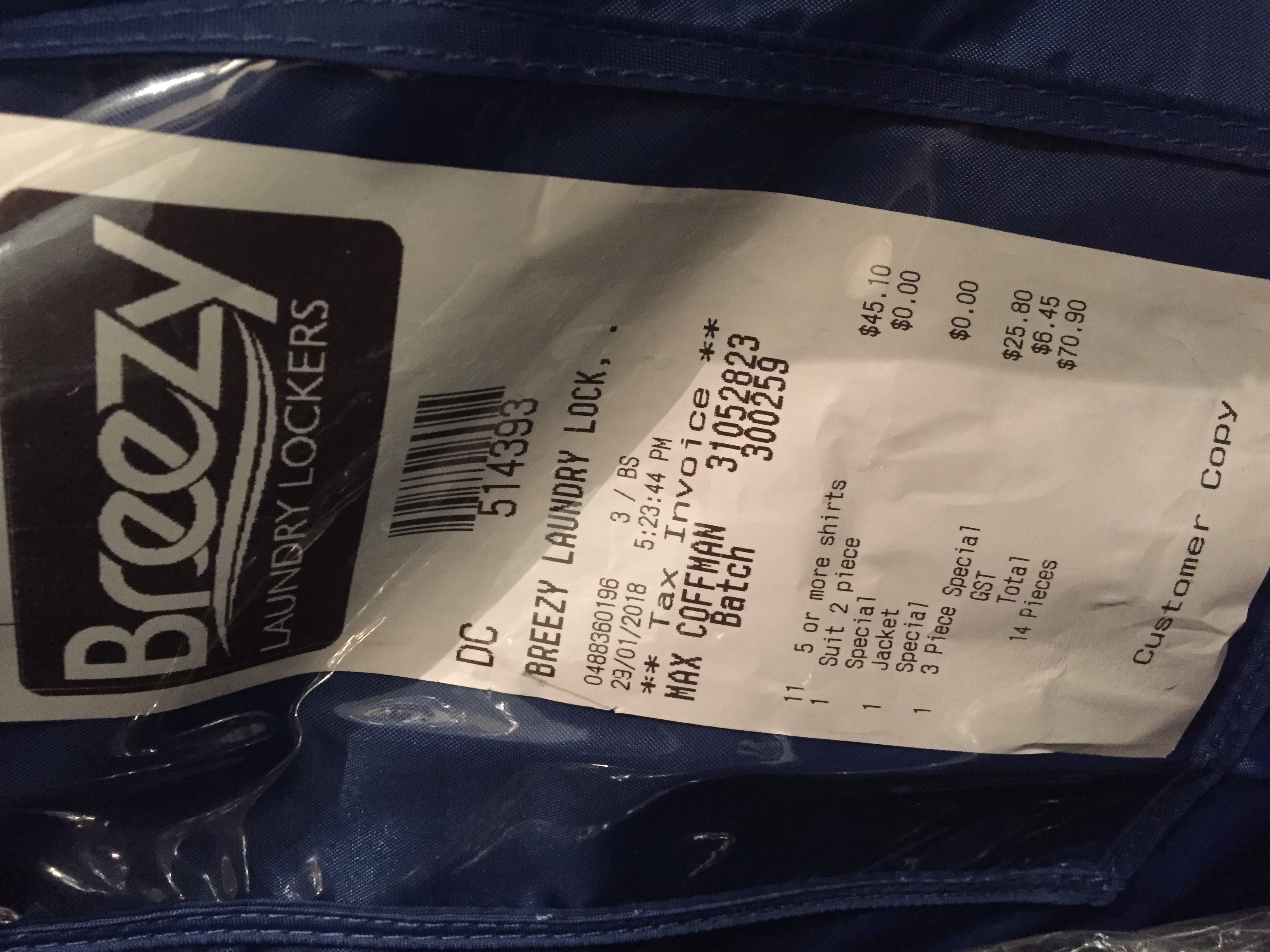 A real customer's tax invoice tag attached to a Breezy garment bag — eleven shirts, a two-piece suit, a jacket, and a 3-piece special, totalling $70.90