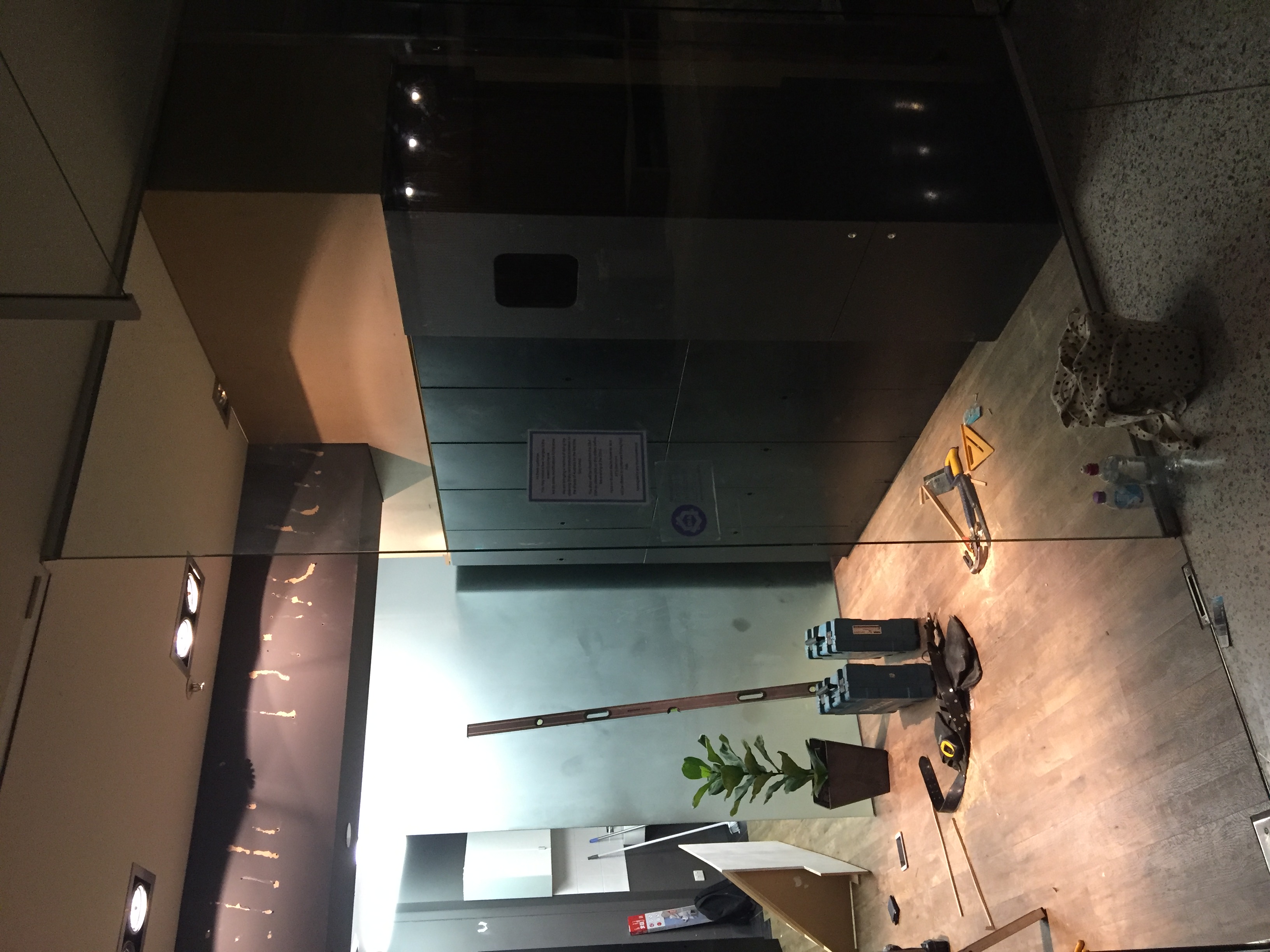 Mid-installation shot showing the black locker bank in place with tools and a level still on the floor before final fitout