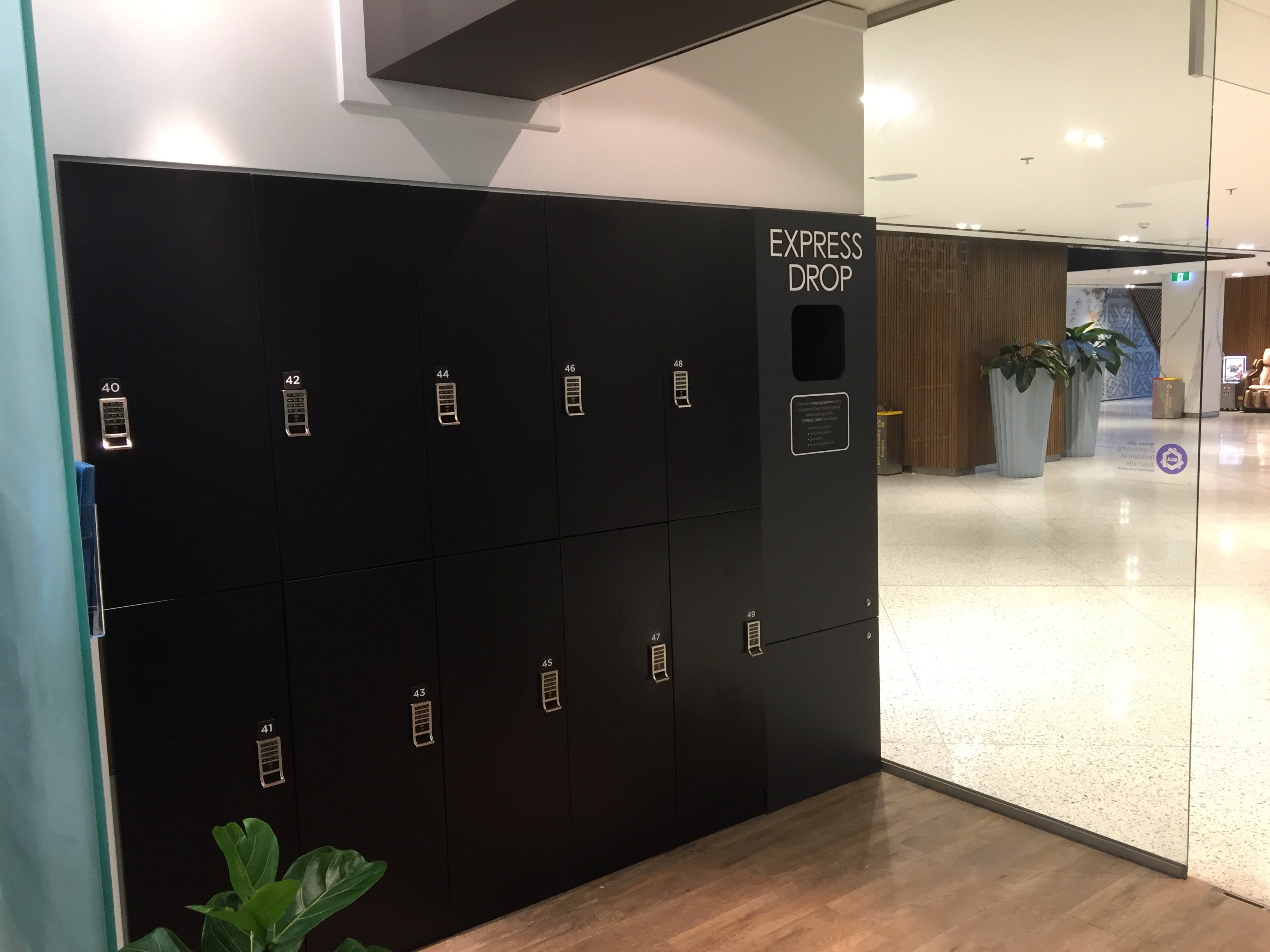 Black Express Drop laundry lockers installed in a polished commercial office building lobby